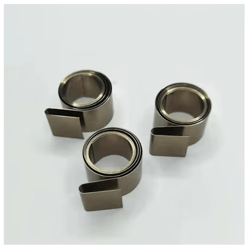 Variable force spring for shelf pusher systems providing smooth and controlled pushing force spring